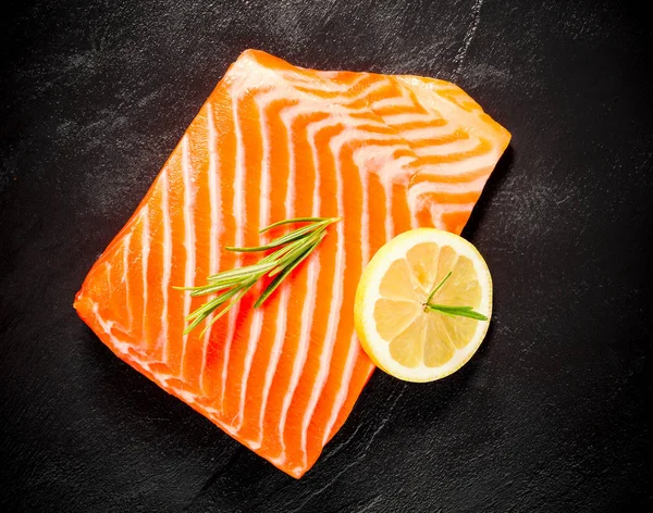 Juicy salmon fillet on black slate plate — Stock Photo, Image