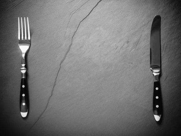 Placa de pizarra negra con cubiertos de bistec, lugar para texto — Foto de Stock