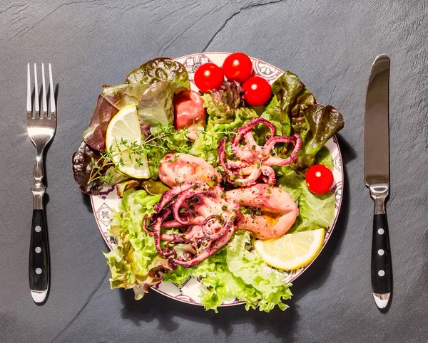 Krake Auf Blauem Teller Mit Salat Und Zitrone Auf Schwarzem — Stockfoto