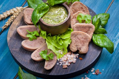 Pesto ve salata ile koyu ahşap tabloda haşlanmış Dana dil