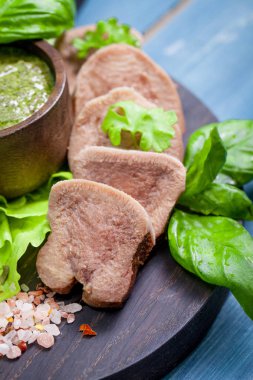 Pesto ve salata ile koyu ahşap tabloda haşlanmış Dana dil