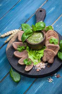 Pesto ve salata ile koyu ahşap tabloda haşlanmış Dana dil