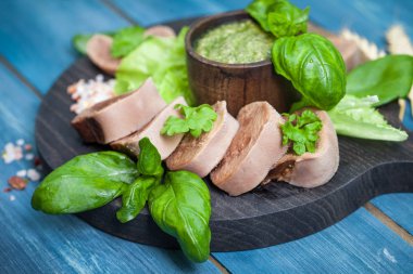 Pesto ve salata ile koyu ahşap tabloda haşlanmış Dana dil