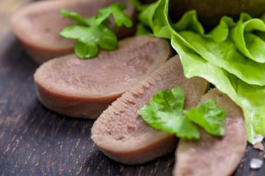 Pesto ve salata ile koyu ahşap tabloda haşlanmış Dana dil