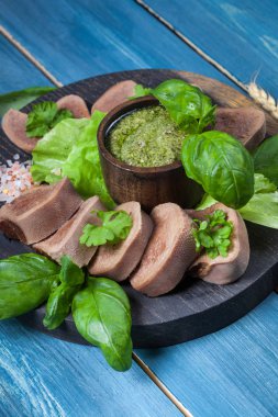 Pesto ve salata ile koyu ahşap tabloda haşlanmış Dana dil