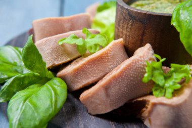 Pesto ve salata ile koyu ahşap tabloda haşlanmış Dana dil