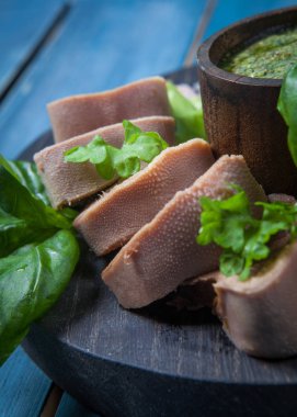 Pesto ve salata ile koyu ahşap tabloda haşlanmış Dana dil