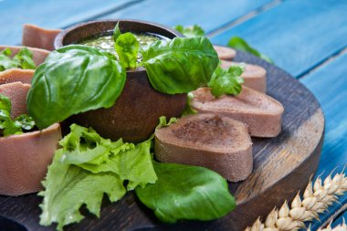 Pesto ve salata ile koyu ahşap tabloda haşlanmış Dana dil