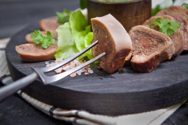 Pesto ve salata ile koyu ahşap tabloda haşlanmış Dana dil