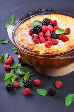 Lor peynirli kek ahududu, böğürtlen ve nane yaprakları ile. Şekersiz. Sağlıklı beslenme. Siyah arka plan