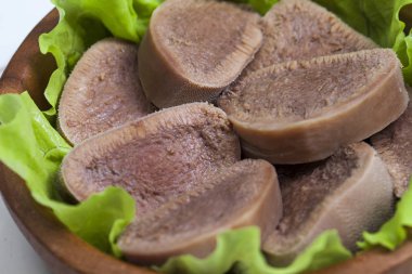 Pesto ve salata ile koyu ahşap tabloda haşlanmış Dana dil