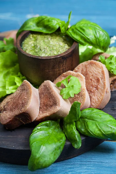 Pesto ve salata ile koyu ahşap tabloda haşlanmış Dana dil