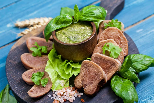 Pesto ve salata ile koyu ahşap tabloda haşlanmış Dana dil