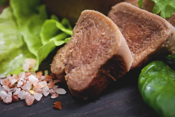 Pesto ve salata ile koyu ahşap tabloda haşlanmış Dana dil