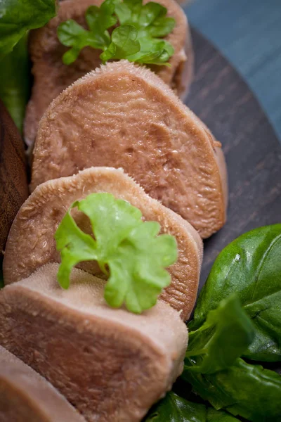 Pesto ve salata ile koyu ahşap tabloda haşlanmış Dana dil