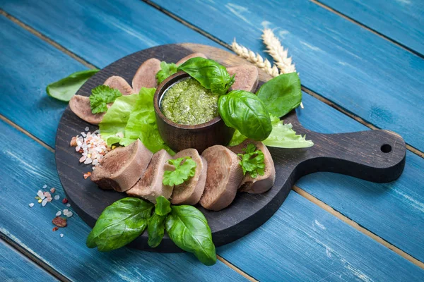 Pesto ve salata ile koyu ahşap tabloda haşlanmış Dana dil