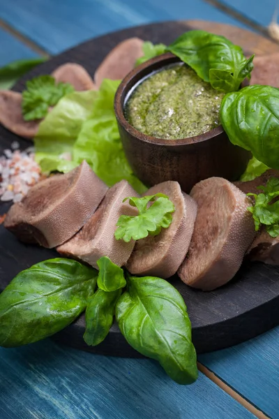Pesto ve salata ile koyu ahşap tabloda haşlanmış Dana dil
