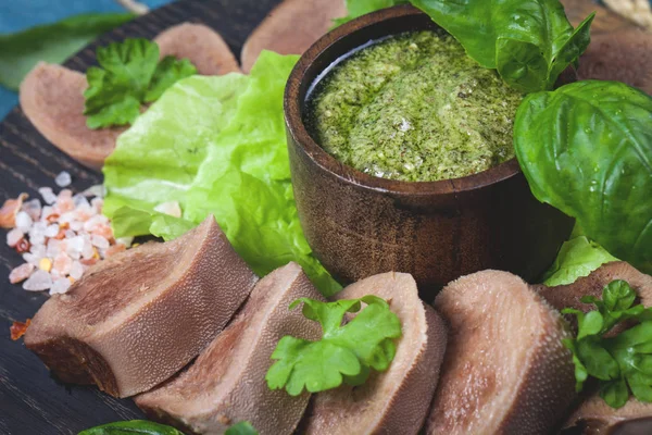 Pesto ve salata ile koyu ahşap tabloda haşlanmış Dana dil
