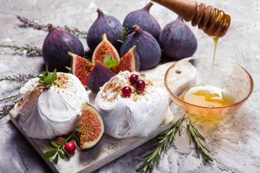 Mini pavlova kek, incir, kızılcık, otlar ve bal