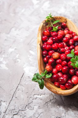 Taze beton yüzeyi ahşap kase kırmızı kızılcık hasat