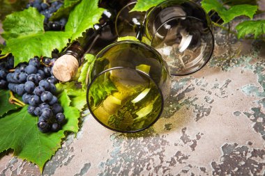 İki boş bardak şişe şarap ve üzüm beton zemin üzerine.