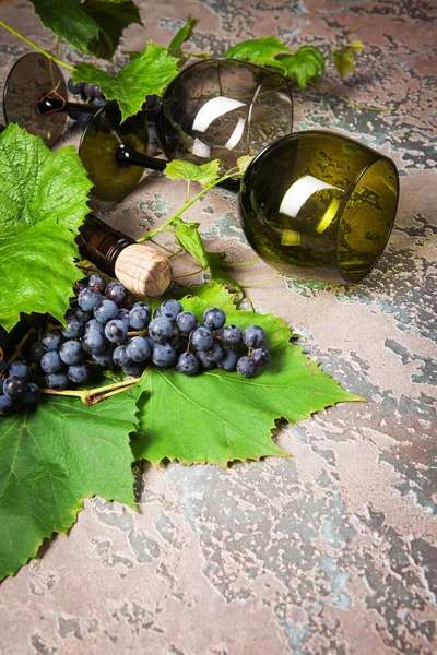 ワインとコンクリート背景にブドウのボトルと つの空のグラス — ストック写真