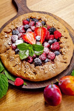 Tam tahıllı Galette'ye Erik beyaz bir tablo ile hazırlanması. üstten görünüm 