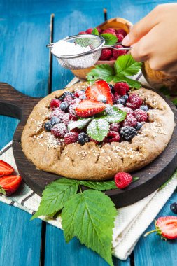Tam tahıllı Galette'ye Erik beyaz bir tablo ile hazırlanması. üstten görünüm 