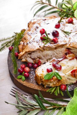 Taze kızılcık ve ahşap plaka üzerinde Noel için otlar ile lezzetli kızılcık pasta.