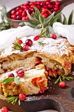 Taze kızılcık ve ahşap plaka üzerinde Noel için otlar ile lezzetli kızılcık pasta.