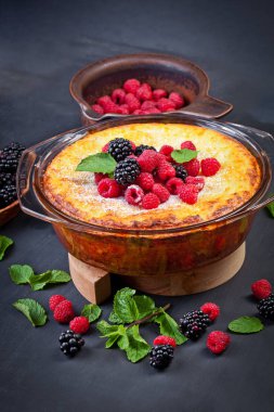 Lor peynirli kek ahududu, böğürtlen ve nane yaprakları ile. Şekersiz. Sağlıklı beslenme. Siyah arka plan