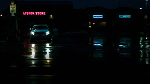 雨天加油站汽车在黑暗中与大灯发光反射在地面上 — 图库照片