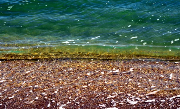 黒海の黒い砂浜の海岸に緑の波 — ストック写真