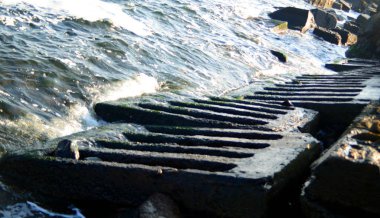 Sonbahar güneşli havalarda taşlı deniz kıyısı beton tabaka