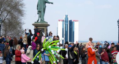 Odessa, Ukrayna - 04 01 2019: Bir grup renkli balon 1 Nisan 'da bir partinin elinde Odessa anıtı ve otelinin arka planına karşı.