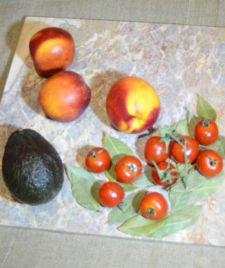 şeftali nektarini, avokado ve kiraz domatesleri mermer arkaplandaki defne yaprakları üzerinde, bir tuval üzerinde yer alır.