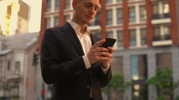 Chico caucásico uso de teléfono inteligente en la ciudad — Vídeos de Stock
