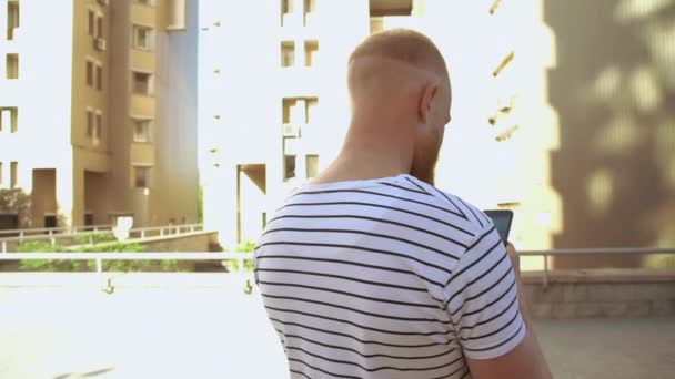モバイル メッセージングを建物の近くに立っている男性 — ストック動画