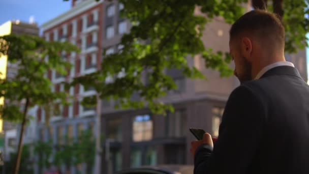 Unternehmer checkt E-Mail auf Smartphone in der Stadt — Stockvideo