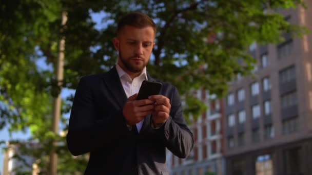 Álló férfi üzenetküldés a városban — Stock videók