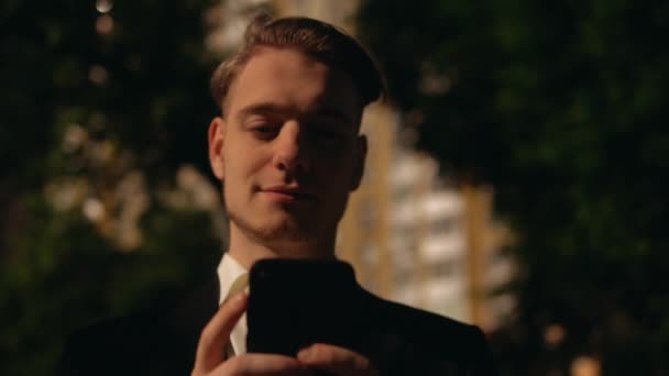 Молодий чоловік отримує повідомлення через мобільний — стокове відео