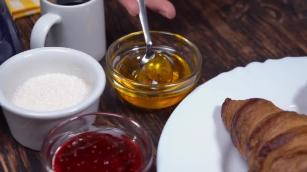 Macro shot of womans hands pouring honey with a tea spoon — Stock Video