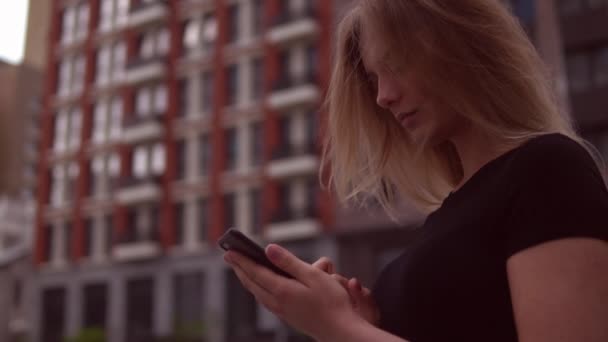 Γυναίκα είναι πληκτρολογώντας ένα μήνυμα στο τηλέφωνό της κινητής τηλεφωνίας — Αρχείο Βίντεο