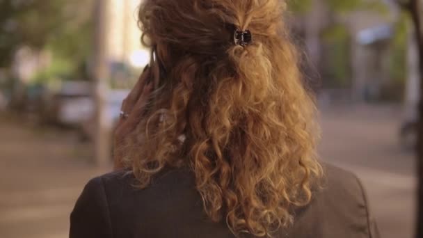 Вид сзади на женщину с вьющимися рыжими волосами — стоковое видео