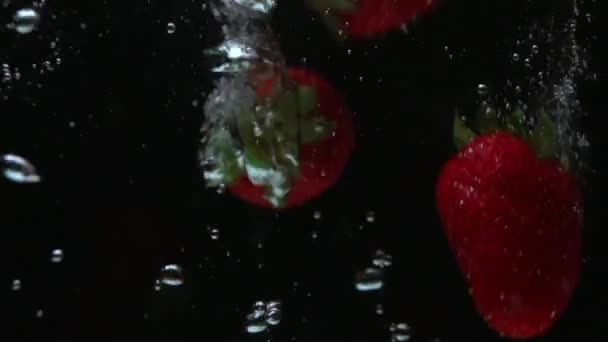 Aardbeien drijvend op de vloeistof — Stockvideo