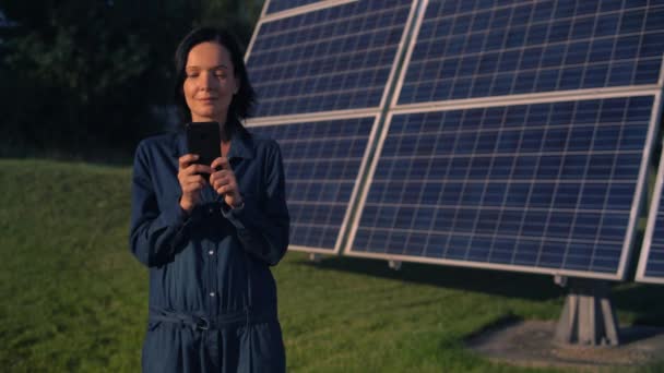 Kvinna med smartphone solar batteri bakgrund — Stockvideo
