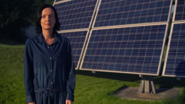 Mujer de pie junto a la batería solar — Vídeos de Stock