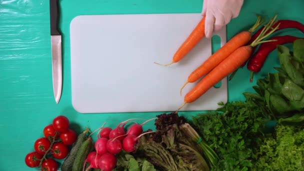 Koch legt Karotten auf den Tisch — Stockvideo