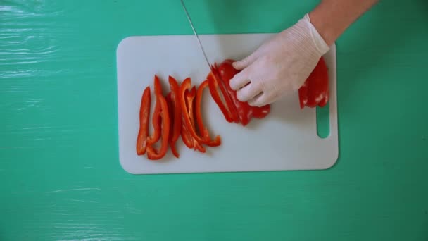 Kucharz mężczyzna jest za pomocą ostrego noża pokroić paprykę — Wideo stockowe