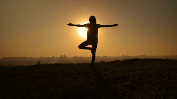 Mujer se levanta contra el sol — Vídeo de stock